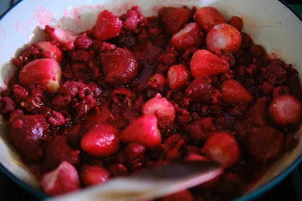 Strawberries and raspberries in a pot starting to simmer for jam